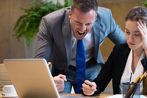 Мужчина кричит на женщину на работе